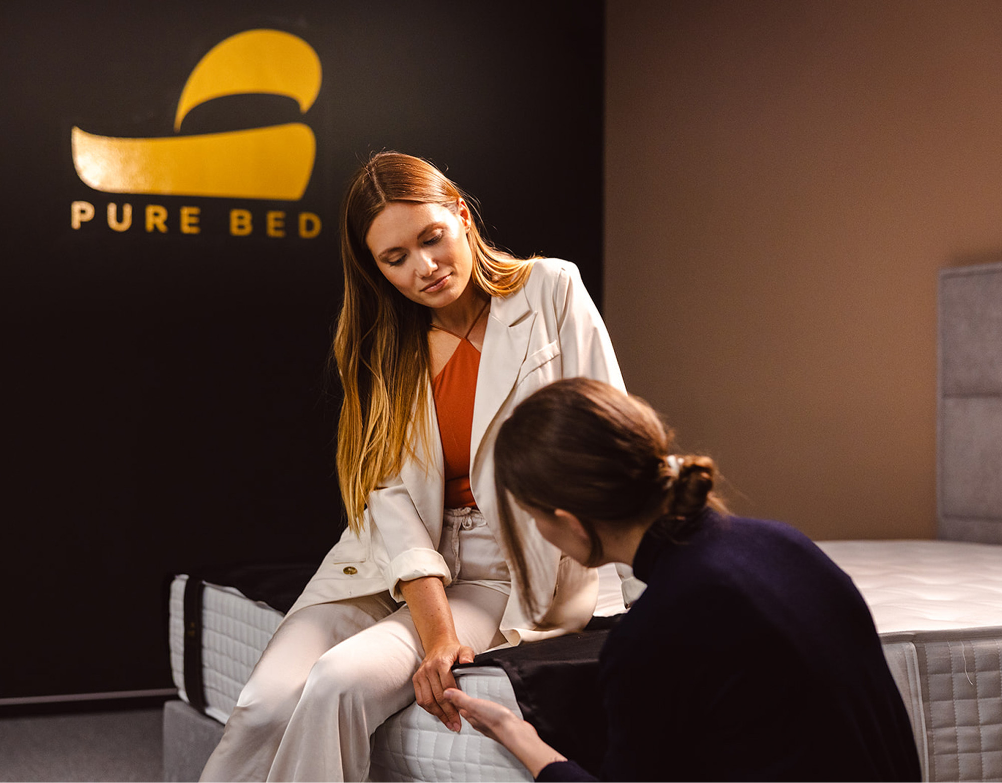 Svetovalka Pure Bed pomaga stranki pri izbiri vzmetnice v showroomu.